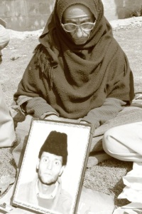 Featured Image: Hussaina Bano, a mother- activist of the Association of the Parents of the Disappeared Persons (APDP) displaying her disappeared son's picture at the monthly protest in 2013